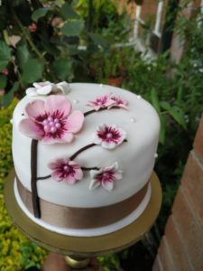 Vista lateral torta en fondant flores exóticas