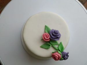 Rosal en fondant sobre hermosa torta con fondo blanco