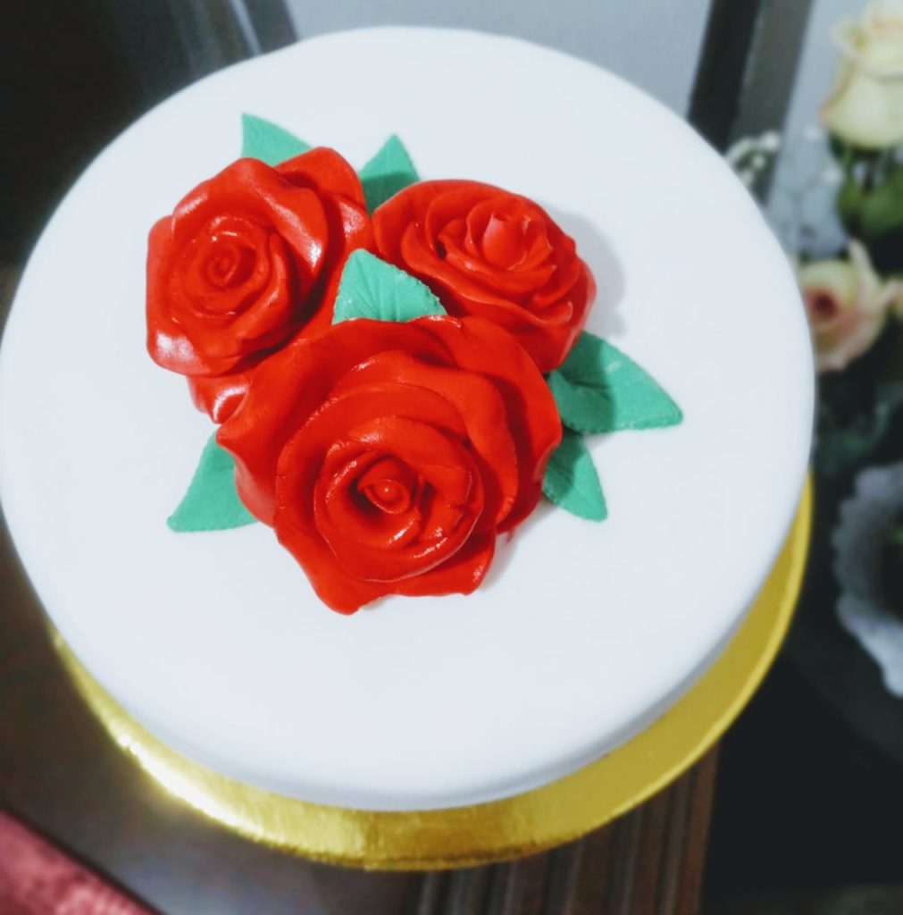 Vista superior Hermosa torta elaborada en fondant con rosas rojas sobre fondo blanco cake by Made