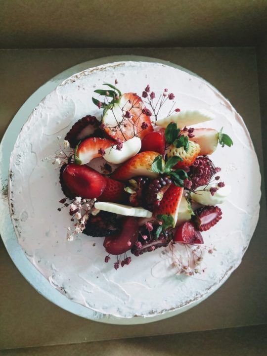Torta desnuda cubierta de crema con fresas