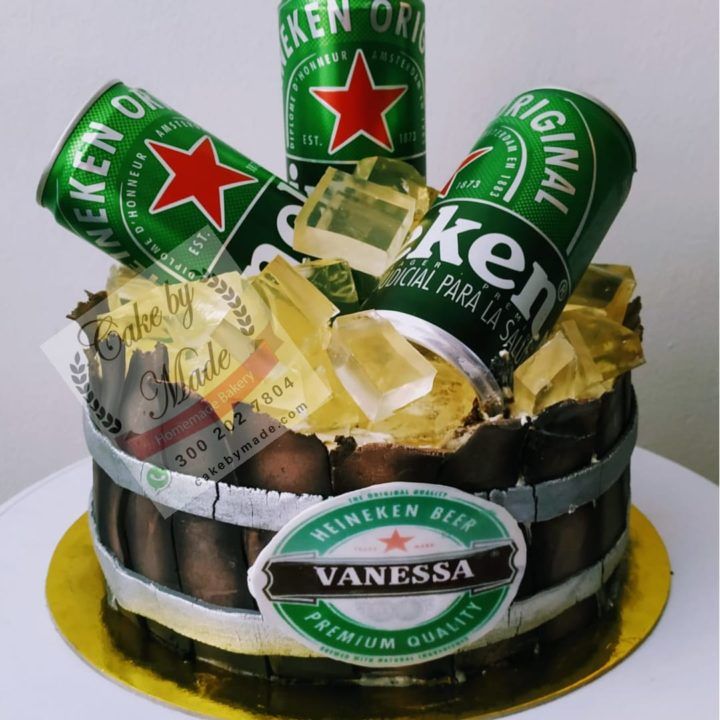 Torta personalizada temática de Heineken, diseñada con un realismo impresionante. El bizcocho de chocolate, cubierto con fondant verde brillante, replica la icónica botella de cerveza Heineken con detalles meticulosos, incluyendo la etiqueta auténtica, la tapa plateada y el logotipo característico. Adornada con una base que simula una caja de madera y detalles adicionales de cebada y lúpulo hechos de azúcar, esta torta no solo es una obra maestra visual, sino también una delicia gastronómica. Perfecta para los amantes de la cerveza y las celebraciones especiales, combina calidad, sabor y creatividad en cada bocado.