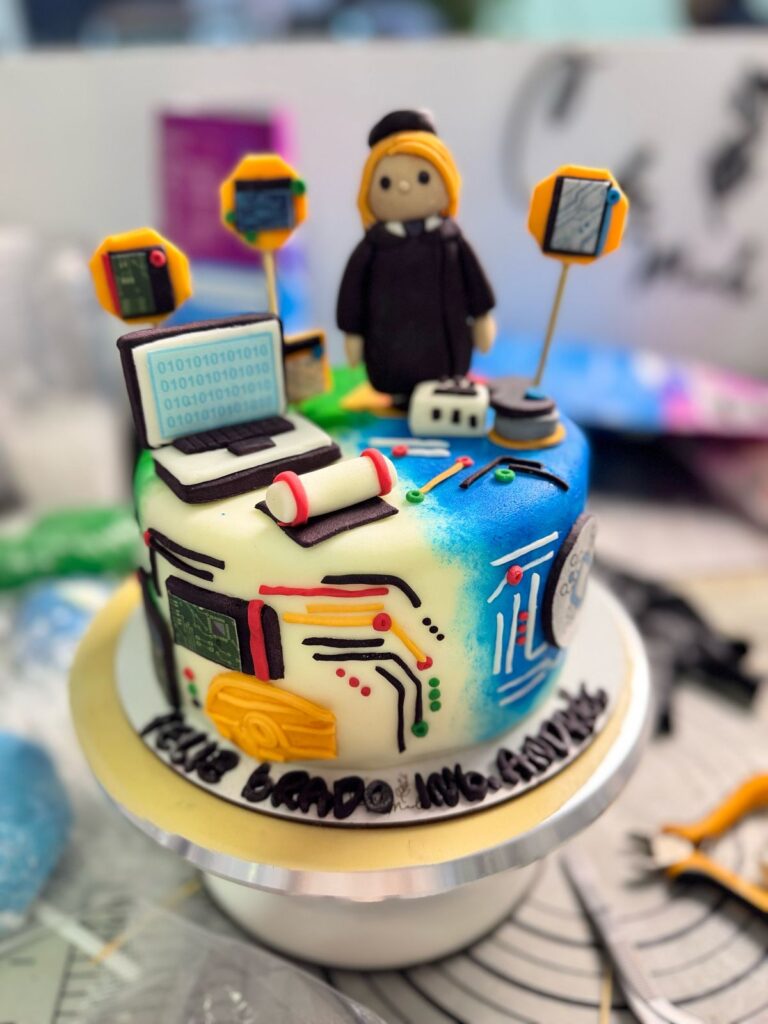 "Torta personalizada de grado para ingeniera electrónica con figuras de fondant como laptop, cables, componentes tecnológicos y muñeca con toga, ideal para celebraciones de graduación en Bogotá"
