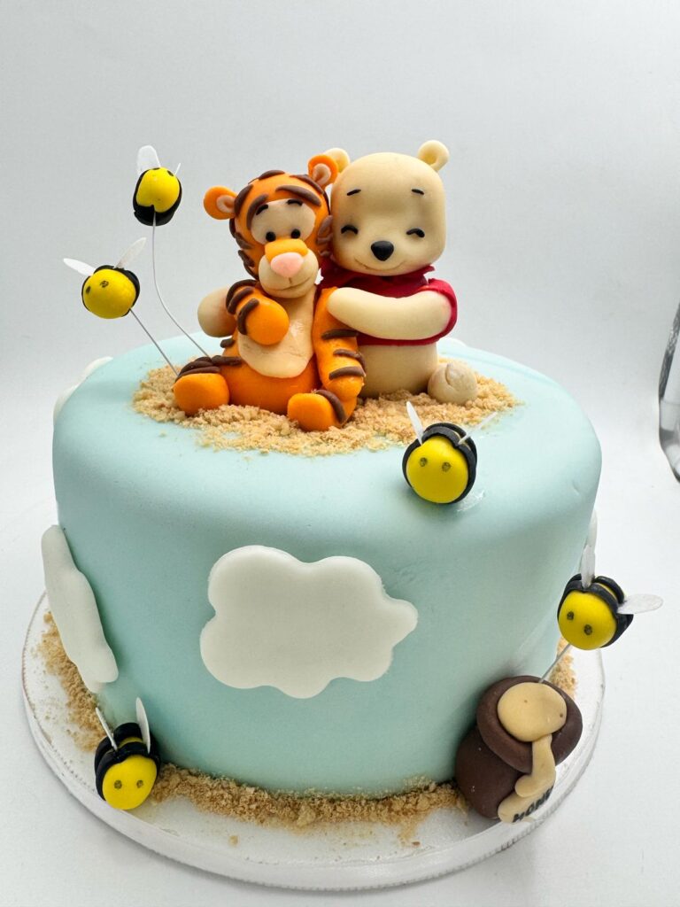 Torta personalizada temática de Winnie the Pooh y Tigger 🎂
Descubre esta hermosa torta decorada infantil con temática de Winnie the Pooh, ideal para cumpleaños de niños o celebraciones especiales. Elaborada con fondant azul pastel, la torta presenta figuras hechas a mano de Pooh y Tigger abrazados, acompañadas de adorables abejitas de azúcar y nubes en 3D que simulan un cielo tierno y divertido. Cada detalle está hecho con precisión y creatividad, ideal para quienes buscan tortas infantiles personalizadas en Bogotá o en cualquier ciudad.Perfecta para quienes desean una torta temática creativa, esta creación de nuestra pastelería combina diseño, sabor y emoción en cada bocado. ¡Haz de tu celebración un momento inolvidable con nuestras tortas personalizadas para niños!