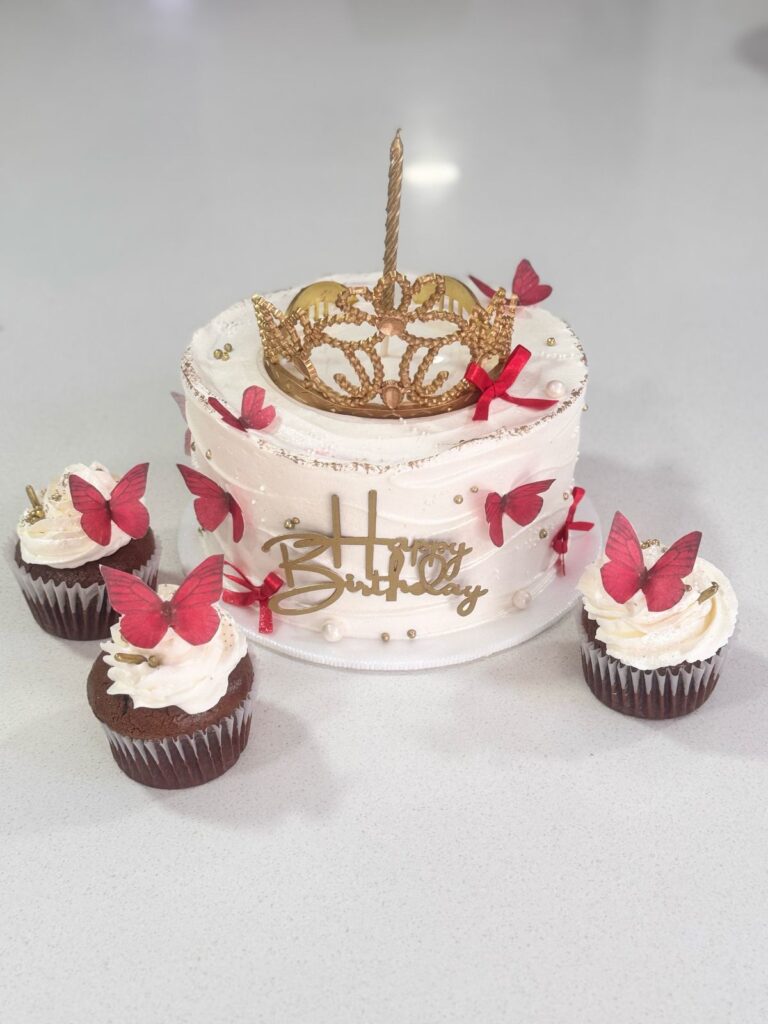 Aquí tienes varias opciones para el atributo ALT de la imagen, optimizadas para SEO, con diferentes enfoques:Opción 1 (Enfoque en el producto):Pastel de cumpleaños con corona dorada y mariposas rojas. Cupcakes de chocolate incluidos. Diseño elegante y festivo para celebraciones infantiles.