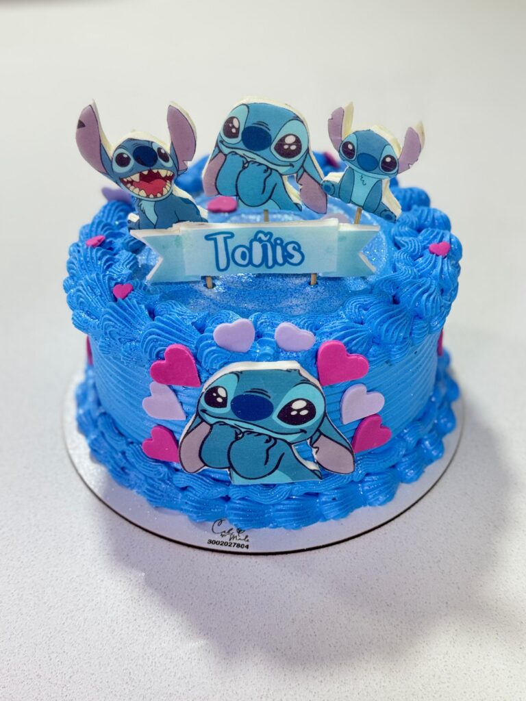 Torta personalizada de Stitch con decoración azul, corazones rosas y toppers comestibles, ideal para cumpleaños infantiles y fiestas temáticas en Bogotá.