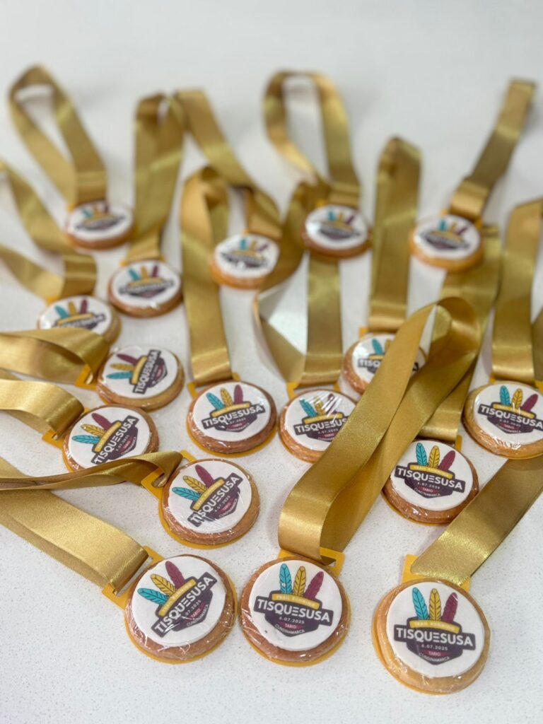 Galletas Personalizadas en Bogotá 19 "Galletas personalizadas tipo medalla con cinta dorada para evento Tisquesusa en Bogotá, diseño comestible con logo y fecha, ideales para premiaciones, celebraciones institucionales o actividades culturales."