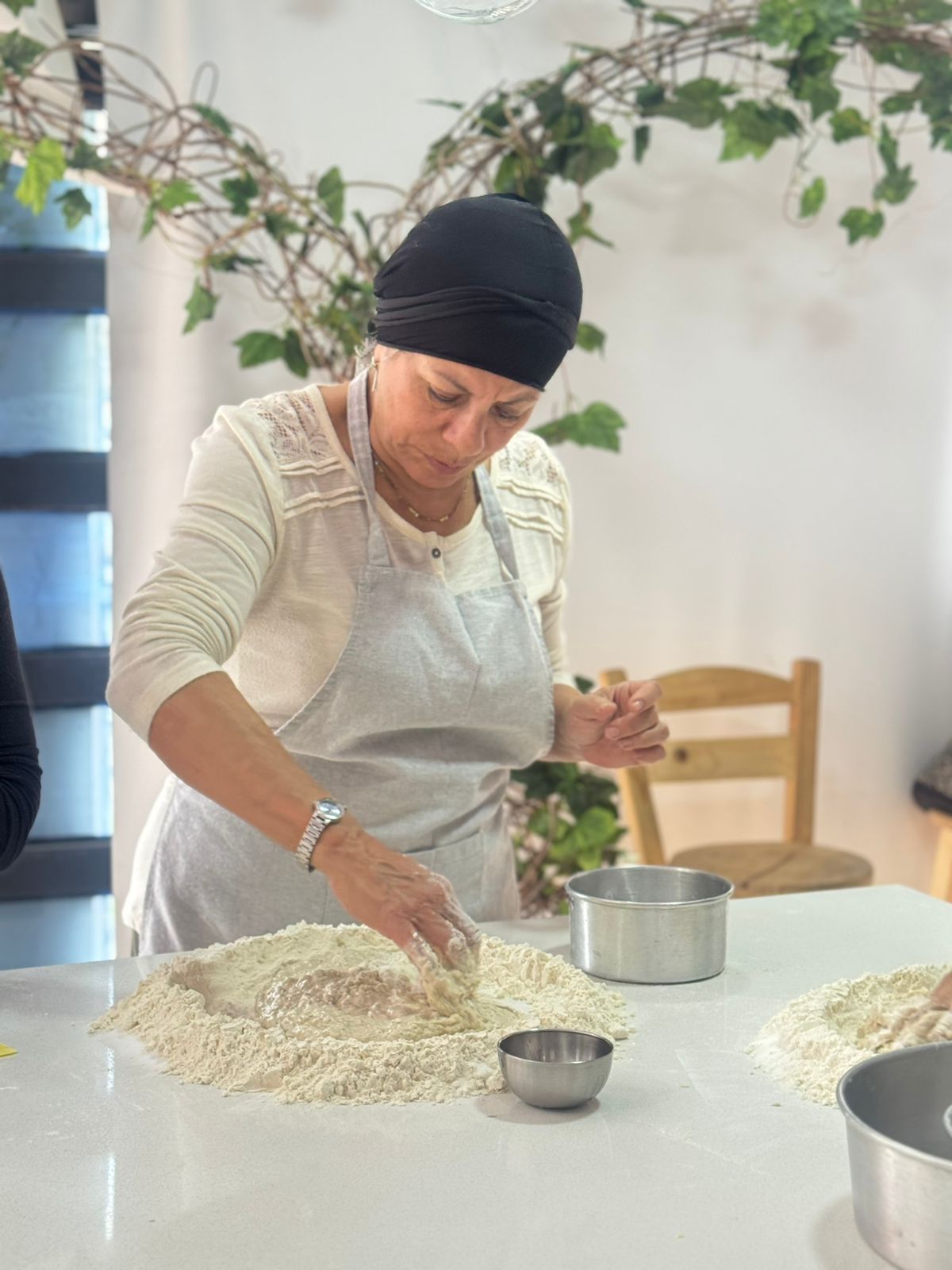 Curso de Masa Madre en Bogotá: Taller Práctico de Pan Artesanal 3 Elaboración de pan de masa madre en Bogotá La foto corresponde a un curso de masa madre Bogotá instructora amasando harina técnicas artesanales taller panadería Cake by Made"