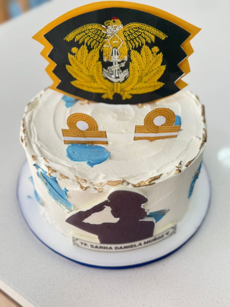 Tortas Personalizadas en Bogotá 53 "Torta personalizada blanca con decoración de la Armada Nacional de Colombia, insignias doradas, silueta de mujer militar saludando y nombre personalizado TR. Sarha Daniela Muñaz V. Pastel artesanal para celebraciones militares, ascensos o grados, elaborado por Cake by Made en Bogotá."