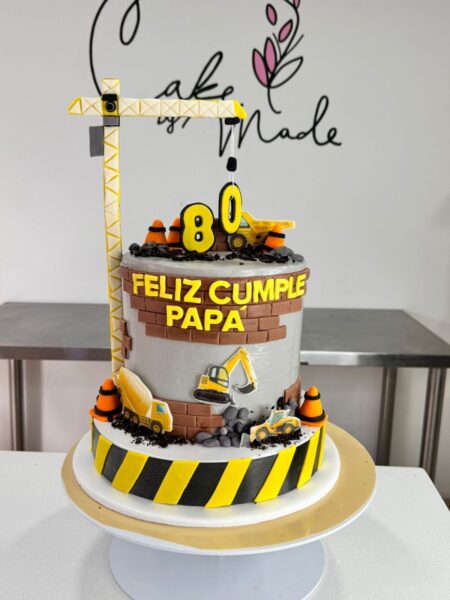Torta personalizada elaborada temática construcción con grúa decorativa, detalles en fondant y acabado artesanal premium