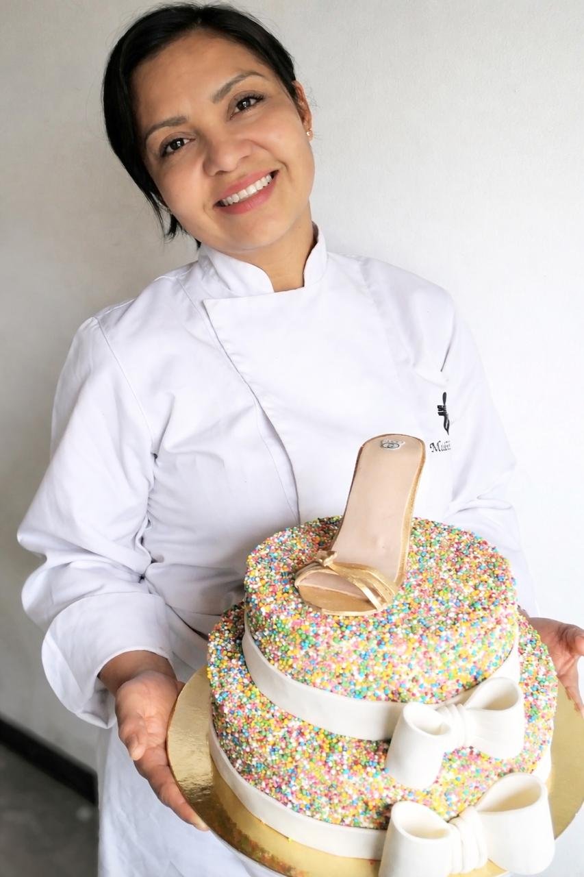 Una linda torta personalizada en primer plano Al fondo la chef Madeleine Barajas Salazar